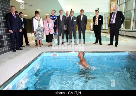 Gli ospiti, tra cui il proprietario del Chelsea FC Roman Abramovich, guardano Ashley Cole nella piscina Hydroworx durante un tour delle nuove strutture di allenamento a Stoke D'Arbenon, Cobham, Surrey. Foto Stock