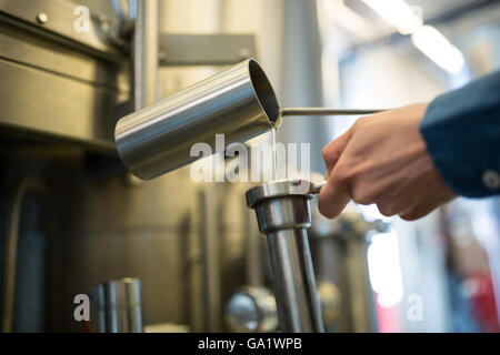 Il birraio e controllare la birra presso la fabbrica di birra Foto Stock