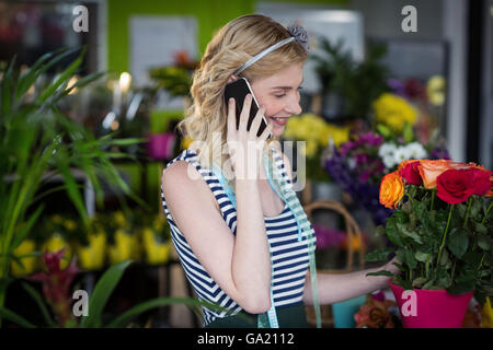 Fiorista femmina parlando al telefono cellulare Foto Stock