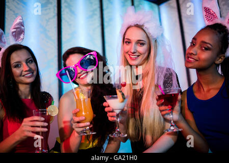 Un gruppo di donne che posano con bicchiere di cocktail Foto Stock