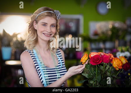 Fiorista femmina toccando rose fiori Foto Stock