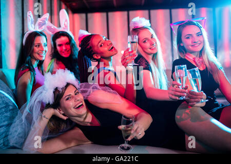 Il gruppo di donne in posa con un bicchiere di champagne Foto Stock