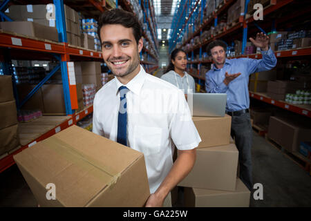 La messa a fuoco del manager tenendo la scatola di cartone e sorridente Foto Stock