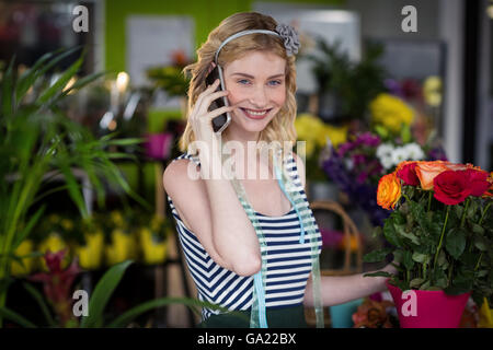 Fiorista femmina parlando al telefono cellulare Foto Stock