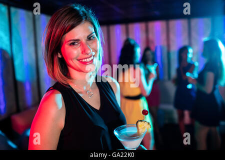 Ritratto di giovane donna avente un cocktail Foto Stock