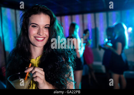 Ritratto di giovane donna avente un cocktail Foto Stock