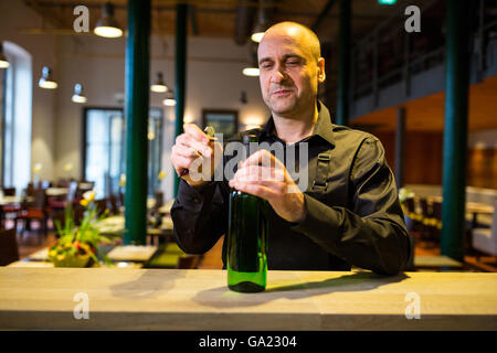 Cameriere di apertura di una bottiglia di vino bianco Foto Stock