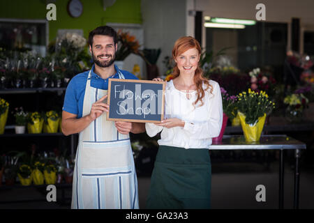 Giovane Azienda ardesia con negozio di fiori segno Foto Stock