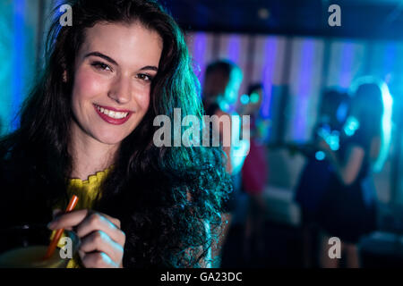 Ritratto di giovane donna avente un cocktail Foto Stock