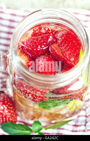 Detox infuso Acqua con limone, fragola e menta su sfondo di legno Foto Stock