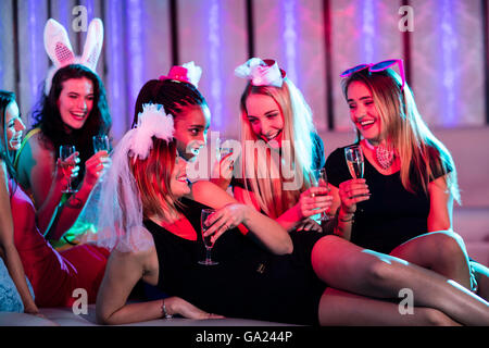 Il gruppo di donne interagire mentre avente un bicchiere di champagne Foto Stock