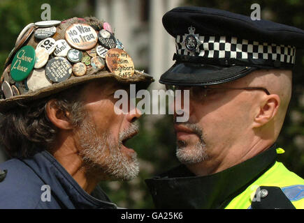 Brian Haw (a sinistra), il protestore anti-guerra, urla contro un poliziotto che è venuto a cercare la sua tenda su Parliament Square, Londra. Foto Stock