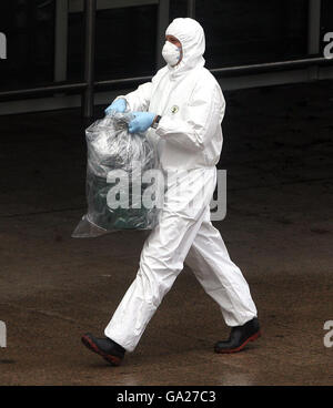 Un ufficiale forense trasporta un contenitore di gas avvolto in plastica dalla scena del drammatico attacco di ieri all'edificio del terminal dell'aeroporto di Glasgow. Foto Stock