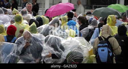 I passeggeri sotto la pioggia al di fuori del Terminal 4 dell'aeroporto di Heathrow, Londra, che è stato evacuato oggi dopo che è stato trovato un pacchetto sospetto. Foto Stock