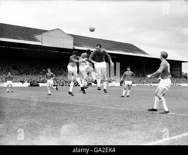 Shay Brennan (terzo l) e Bill Foulkes (c) del Manchester United sfidano il Leyton Orient Center in avanti per una testata, guardato dal compagno di squadra Denis Law (r) Foto Stock