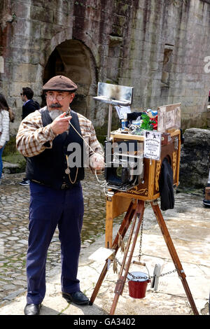 Un fotografo di strada in Santillana del Mar prende un sacco di business da turisti che visitano il borgo antico. Foto Stock