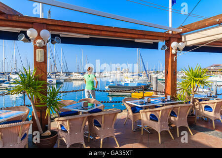 MARINA RUBICON, Lanzarote Island - Jan 17, 2015: il giovane turista in piedi in ristorante nel Rubicone yacht port. Lanzarote è meta di vacanze grazie al soleggiato clima tropicale. Foto Stock