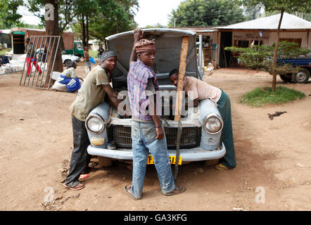 Gli uomini la riparazione di un automobile in alla Marangu village, il Parco Nazionale del Kilimanjaro, Tanzania, Africa orientale, Africa Foto Stock