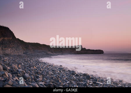 Kilve Beach dopo il tramonto, con lavaggio onde sopra le rocce allentati, Somerset, Inghilterra, Regno Unito, Europa Foto Stock
