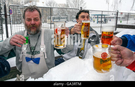 Gli uomini cechi che bevono birra, i cechi, i Drinkers nella birreria all'aperto invernale, la Repubblica Ceca beve con gli amici della neve bevono le birre Foto Stock