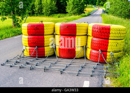 Diga fatta di giallo e rosso dipinto di pneumatici per auto. Ponte dietro è ottenere nuove ringhiere per maggiore sicurezza. Foto Stock