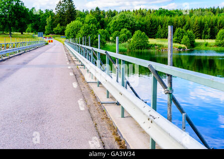 Riparazioni in corso di un ponte di ringhiere per migliorare la sicurezza. Blocchi stradali visibile in background. Foto Stock