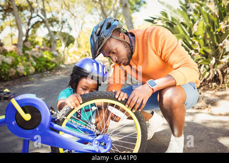 Famiglia la riparazione di una bicicletta Foto Stock