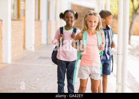 Ragazzi delle scuole in piedi nel corridoio della scuola Foto Stock
