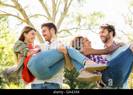 L uomo dando sovrapponibile alla donna pur avendo un bicchiere di birra Foto Stock