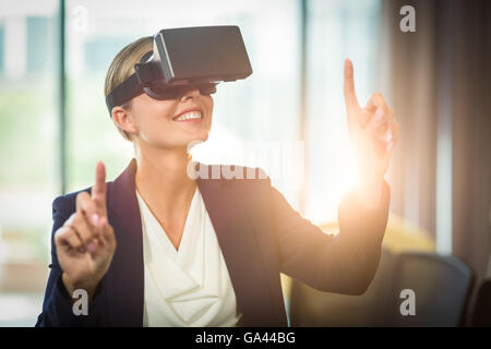 Imprenditrice utilizzando la realtà virtuale auricolare Foto Stock