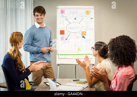 I colleghi ad applaudire un collega dopo la presentazione Foto Stock