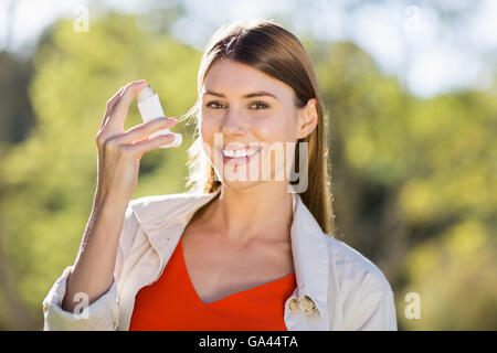 Ritratto di donna bella utilizzando l'asma inalatore Foto Stock