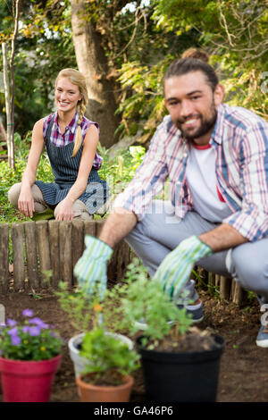 Ritratto di felice giardinieri accovacciato in giardino Foto Stock