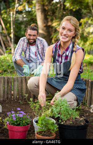 Ritratto di giardiniere felice con il collega la semina in giardino Foto Stock