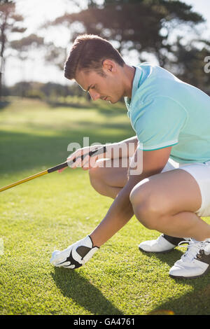 Il Golfer uomo posizionando la pallina da golf sul raccordo a T Foto Stock