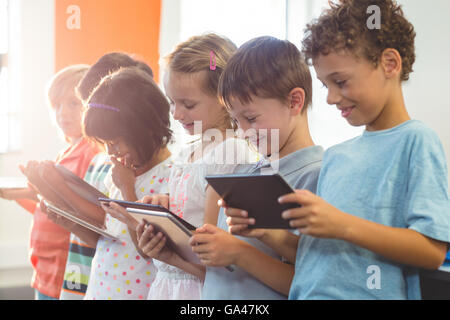 Bambini sorridenti utilizzando compresse digitale Foto Stock