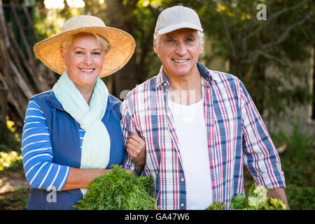Ritratto di coppia felice con verdure in giardino Foto Stock