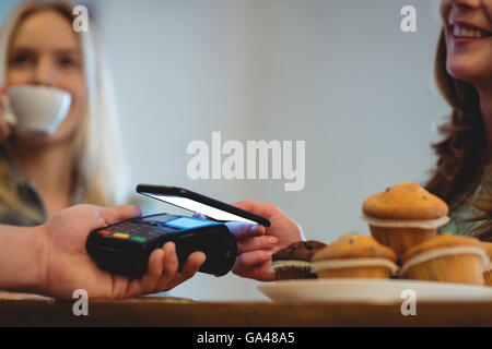 Close-up del barista e cliente con tecnologie presso il cafe Foto Stock