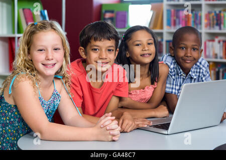 Felici i compagni di scuola con il computer portatile Foto Stock