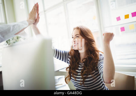 Emozionato i colleghi dando ad alta cinque presso il creative office Foto Stock