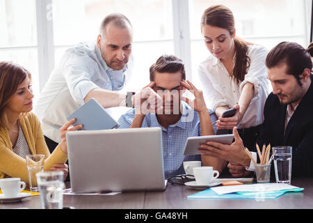 Imprenditore irritata tra colleghi che mostra le tecnologie Foto Stock