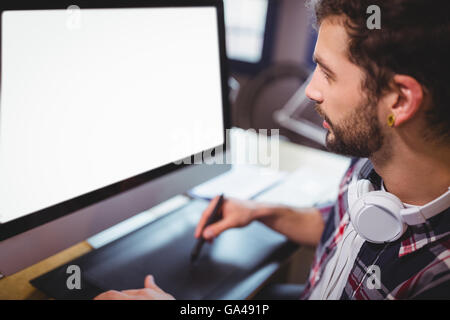 Graphic designer guardando il monitor di un computer mentre si lavora Foto Stock
