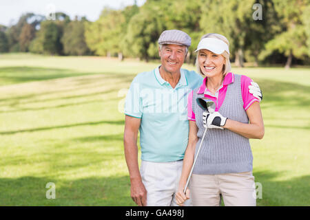 Sorridente Coppia matura permanente al campo da golf Foto Stock