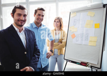 Sorridente interior designer in piedi vicino a bordo Foto Stock