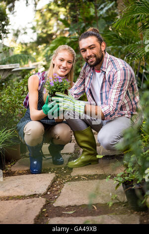 Ritratto di giardinieri azienda pianta in vaso in giardino Foto Stock
