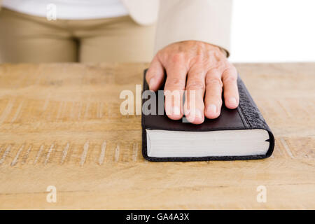 Sezione mediana della donna con la mano sulla Bibbia Foto Stock