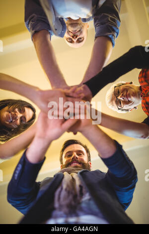 Happy business persone mani di impilamento in ufficio creativo Foto Stock