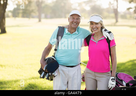 Felice coppia golfista giovane con braccio intorno a Foto Stock