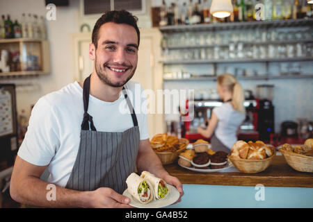 Ritratto di felice barista con panini freschi Foto Stock