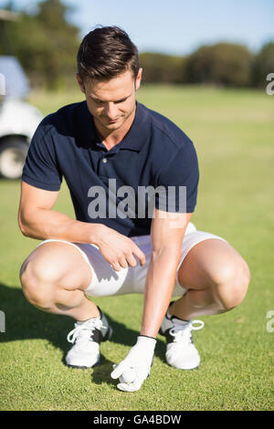 Lunghezza completa uomo posizionando la pallina da golf sul raccordo a T Foto Stock